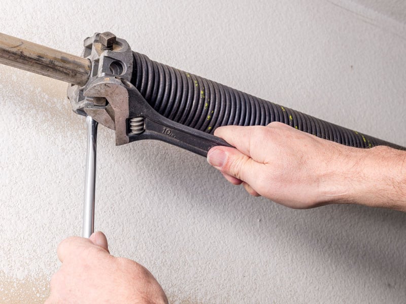 overhead door company garage door spring persons hands repairing replacing